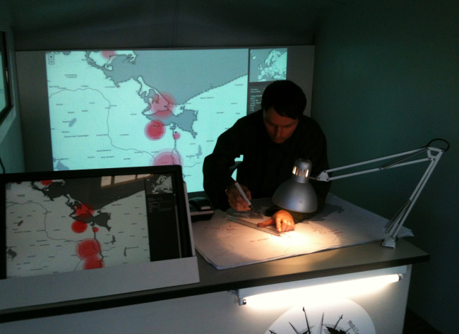 Julian Oliver behind the desk of his Border Bumping aaravan