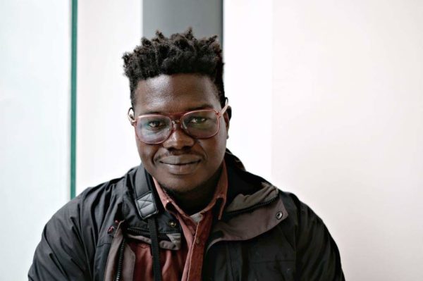 image of man in jacket with glasses on against white background