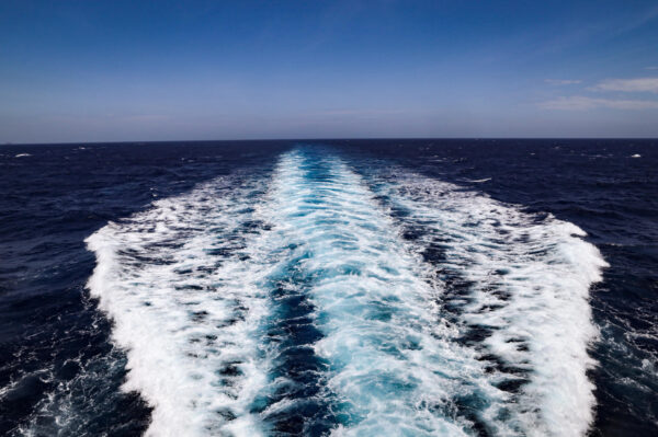 Water trails from boat looking into horizon