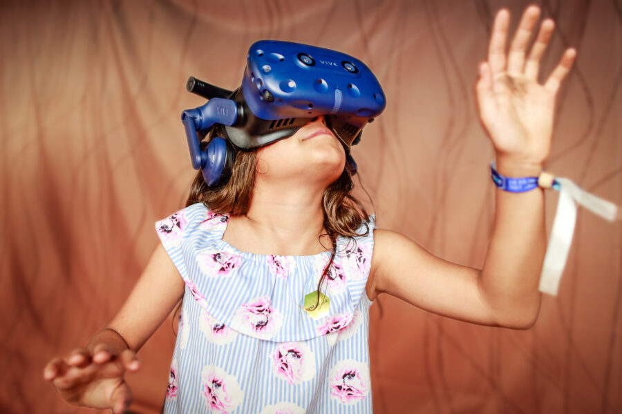 Young girl inside a virtual reality experience against orange background