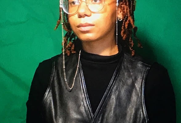 women in black with glasses against green background