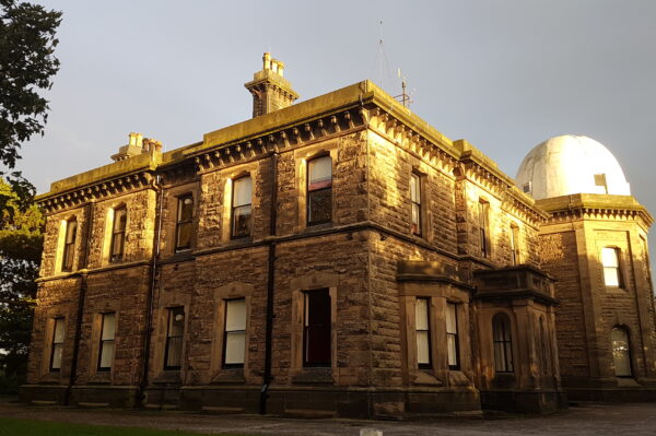 Old building with light shining on it. Dome roof to the right