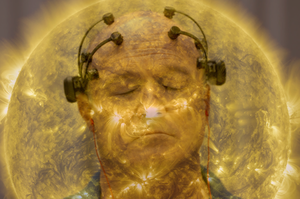 Man with probes on head and eyes closed with sun in backgound