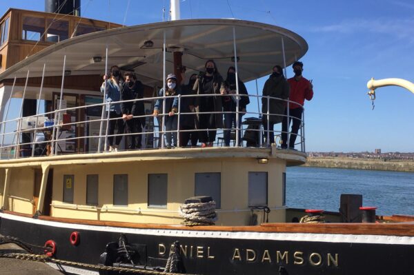 People waving from the deck of a boat