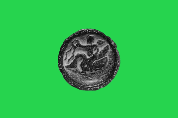 Old black coin on green background